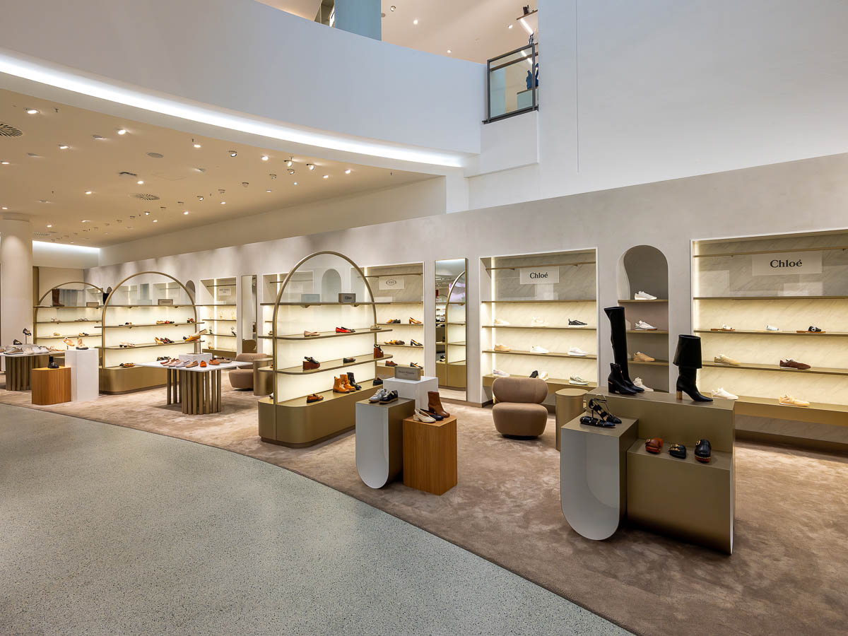 Im Untergeschoss erwartet Besucherinnen und Besucher eine der größten Damenschuhwelten Bayerns. Neben einer exklusiven Auswahl an Premium- und Luxusschuhen finden sich hier auch angesagte Sneakermodelle und bewährte Klassiker. Ein Sneaker Cleaning Service sowie wechselnde Pop-ups renommierter Marken runden das Angebot ab.