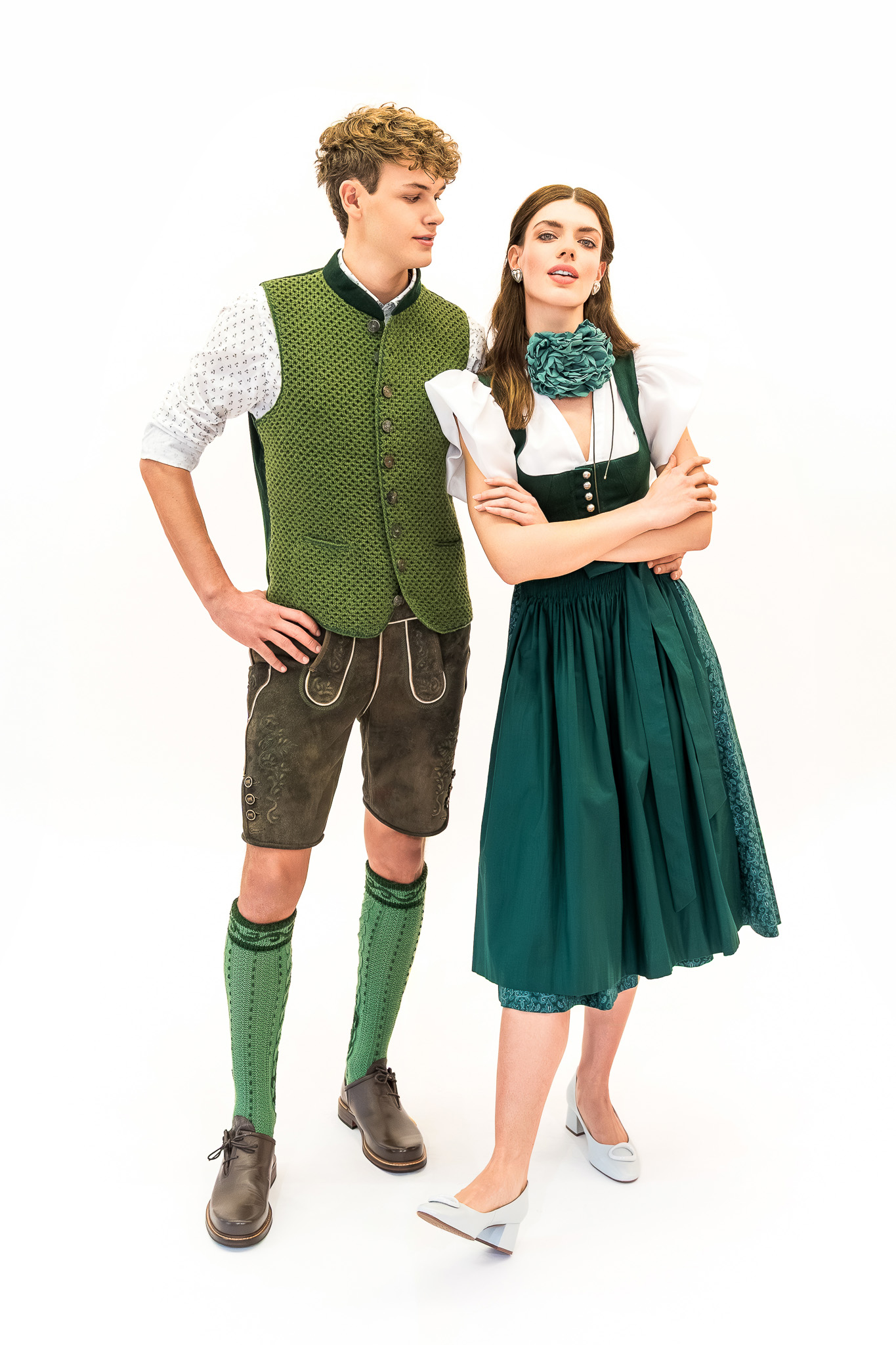 lederhose-dirndl-gruen-trend-2026 Grünes Dirndl mit moderner Bluse und Lederhose mit Strickweste – Dirndl und Lederhose Trend Frühjahr Sommer 2026.