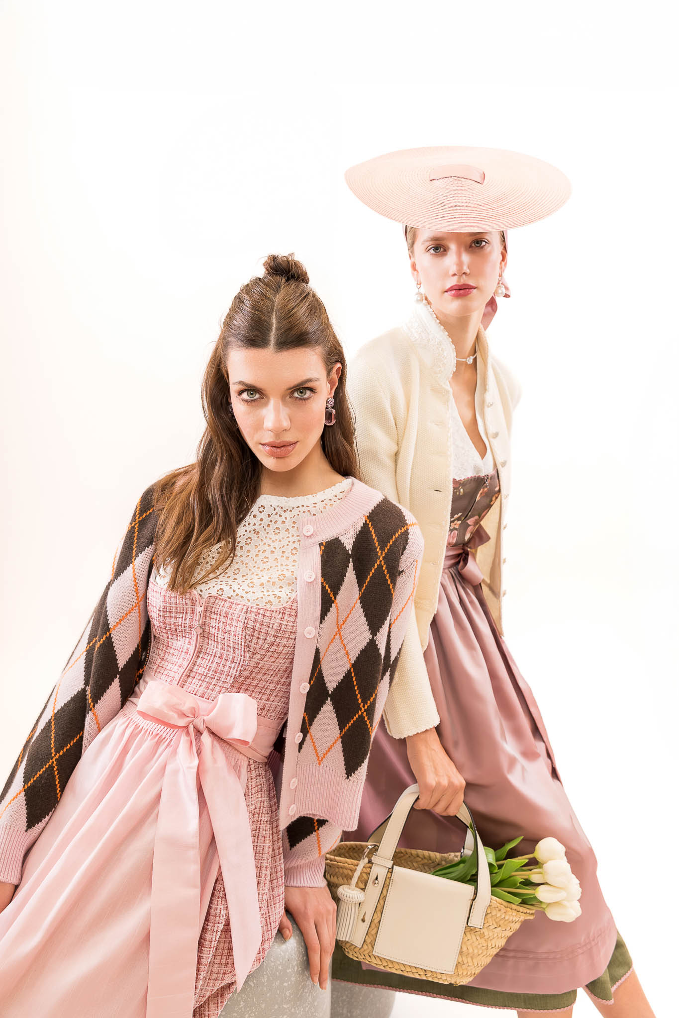 dirndl mit strickjacke tracht trend 2026 Modernes Dirndl mit Argyle-Strickjacke, Schleifenschürze und Accessoires – Tracht Frühjahr Sommer 2026.