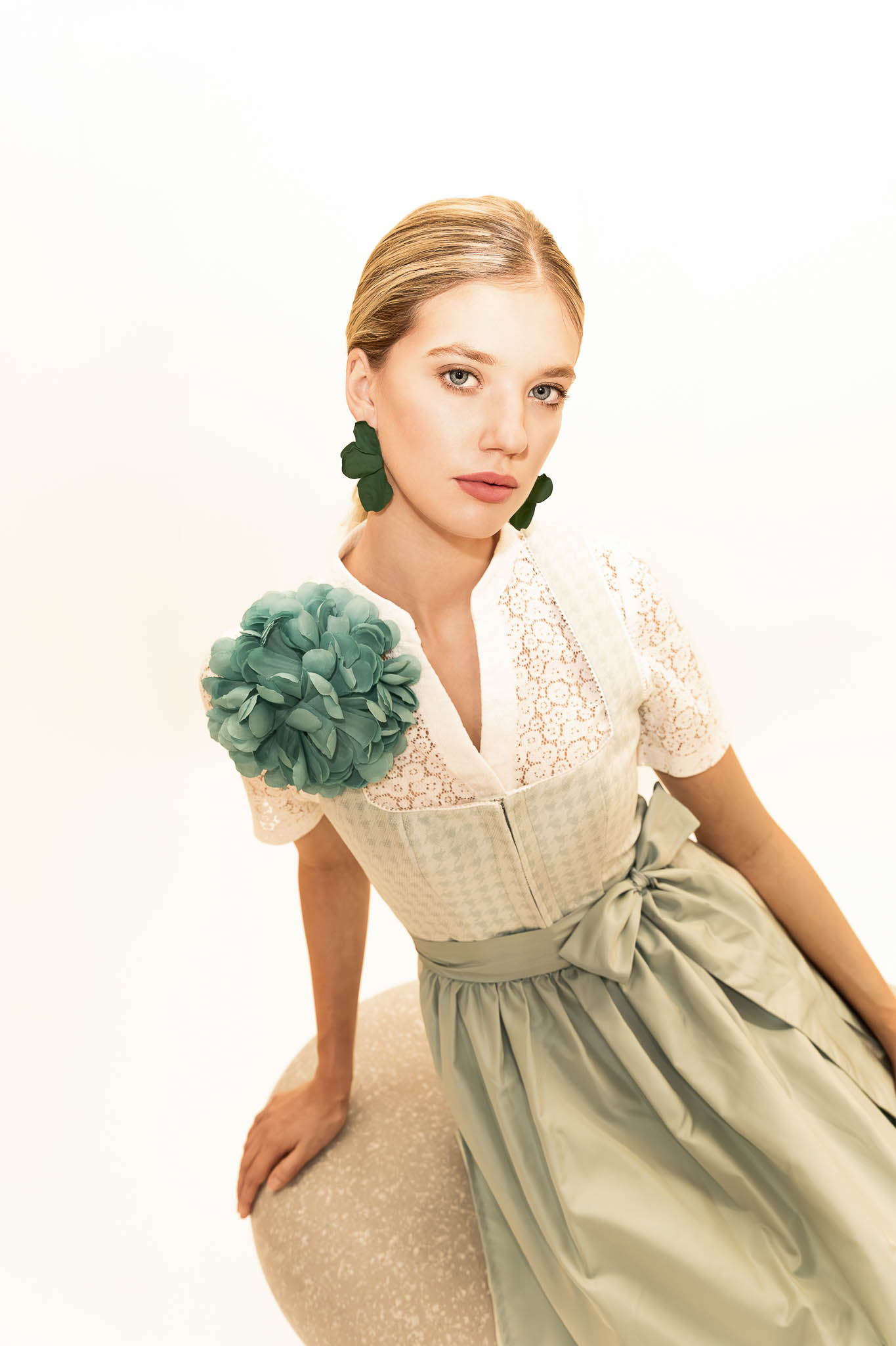 Dirndl in Pastellgrün mit Spitzenbluse Pastellgrünes Dirndl mit Spitzenbluse und floralen Accessoires – Dirndl Trends Frühjahr Sommer 2026.