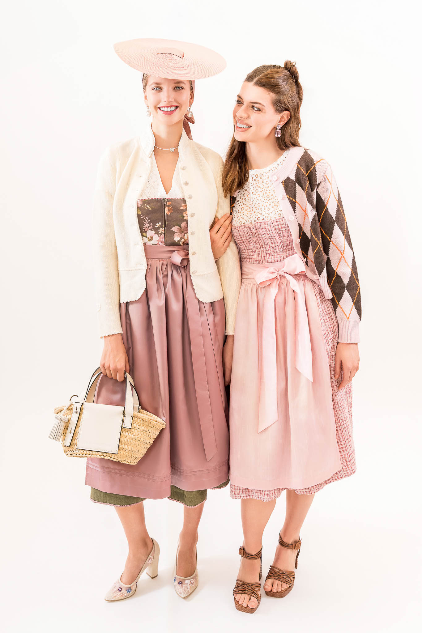 dirndl trends 2026 rose dirndl strohtasche Zwei Dirndl-Looks in Rosé mit Strickjacke, floralen Details und Strohtasche – Dirndl Trends Frühjahr Sommer 2026.