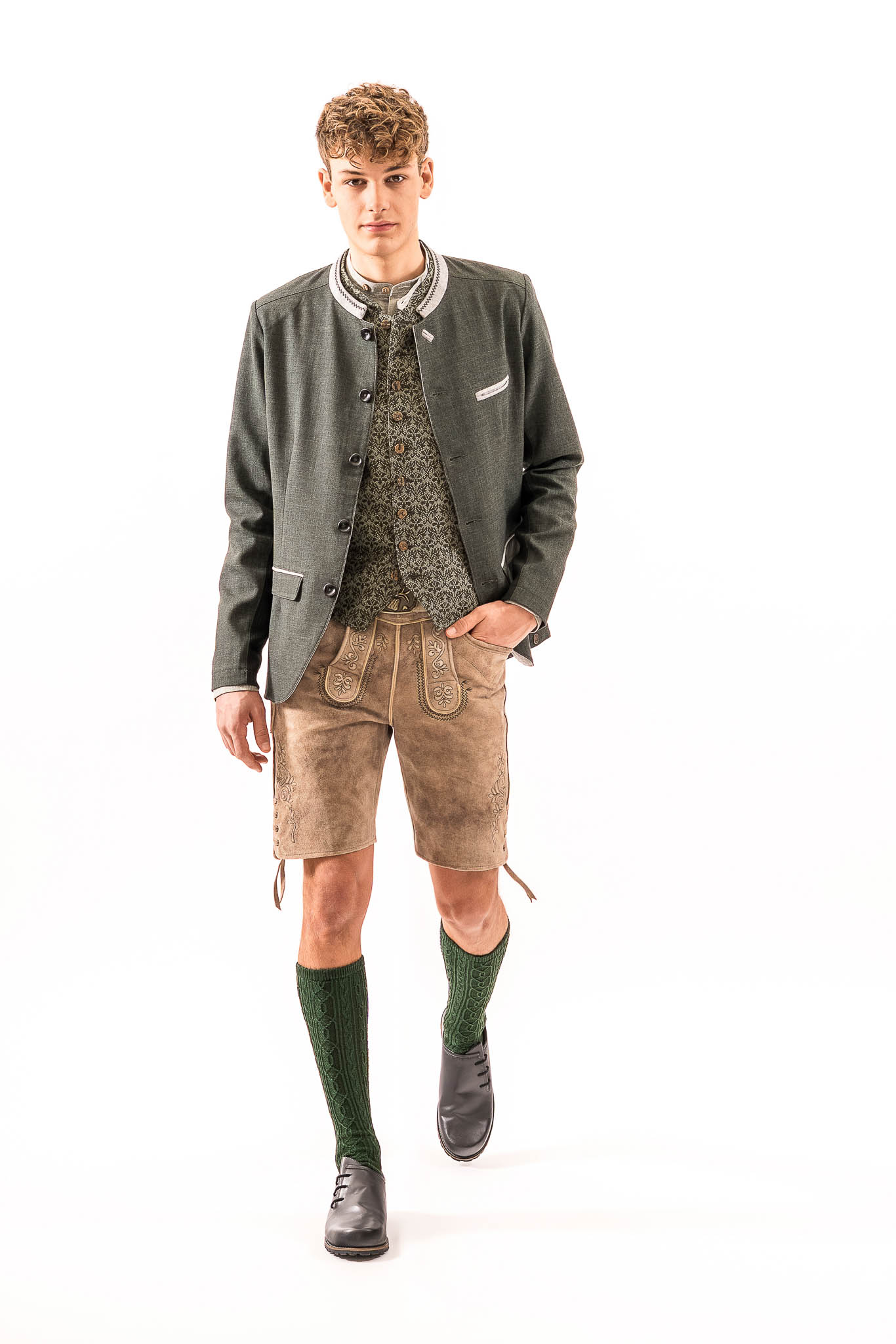 Moderner Herrenlook mit Lederhose und Stehkragensakko Moderner Trachtenlook für Herren mit Lederhose, Weste und Stehkragensakko – Lederhose Trend Frühjahr Sommer 2026.
