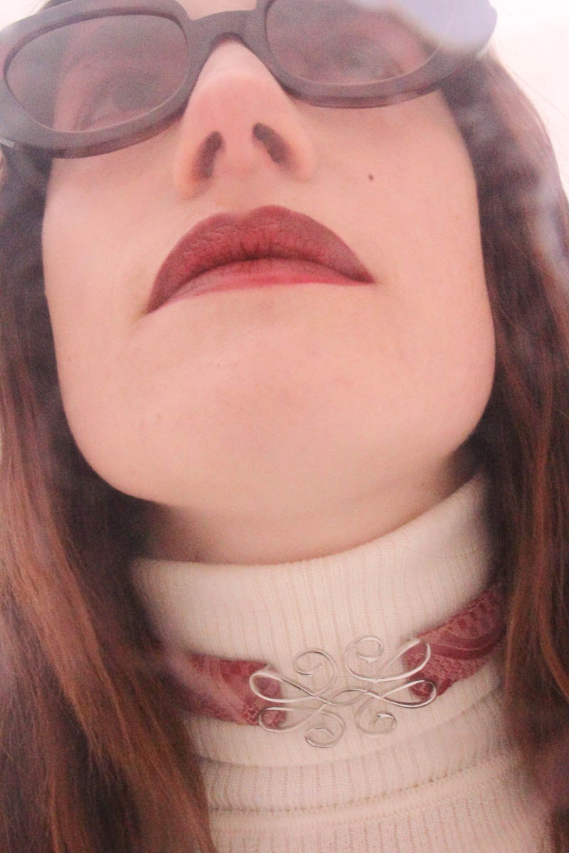 Nahaufnahme einer Frau mit Sonnenbrille und handgefertigtem Choker von MARIAHAUSE am Hals