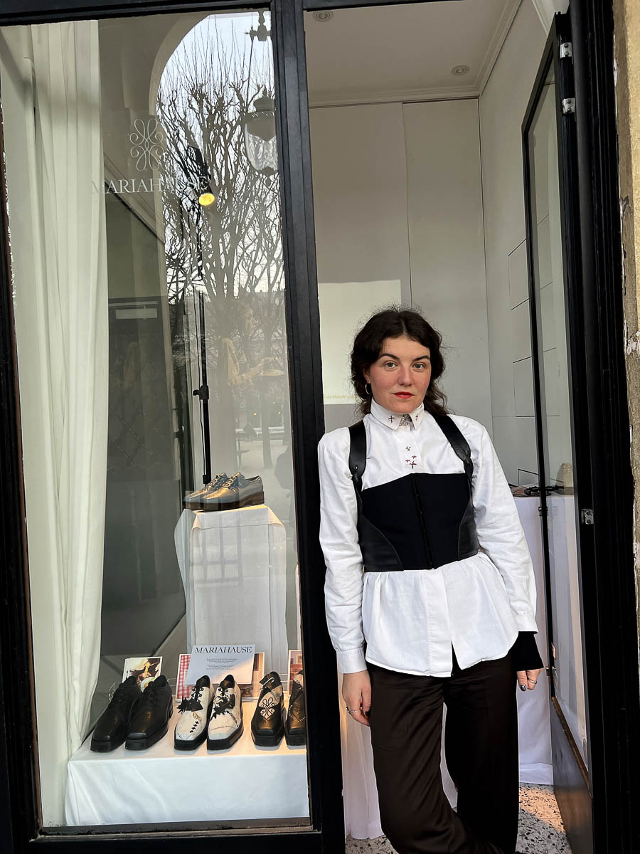 Marie Weber steht vor einem Geschäft mit ausgestellten Schuhen von MARIAHAUSE