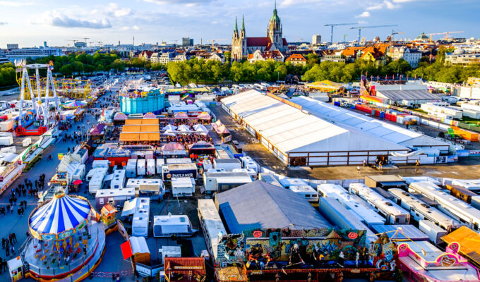 Münchner Frühlingsfest 2026 auf der Theresienwiese mit Fahrgeschäften, Bierzelten und Blick über München. © fottoo - stock.adobe.com
