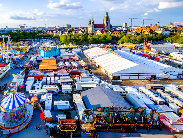 Münchner Frühlingsfest 2026 auf der Theresienwiese mit Fahrgeschäften, Bierzelten und Blick über München. © fottoo - stock.adobe.com