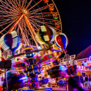 Fahrgeschäfte auf dem Villacher Kirchtag bei Nacht mit bunten Lichtern. Foto: AdobeStock/ANDREAS