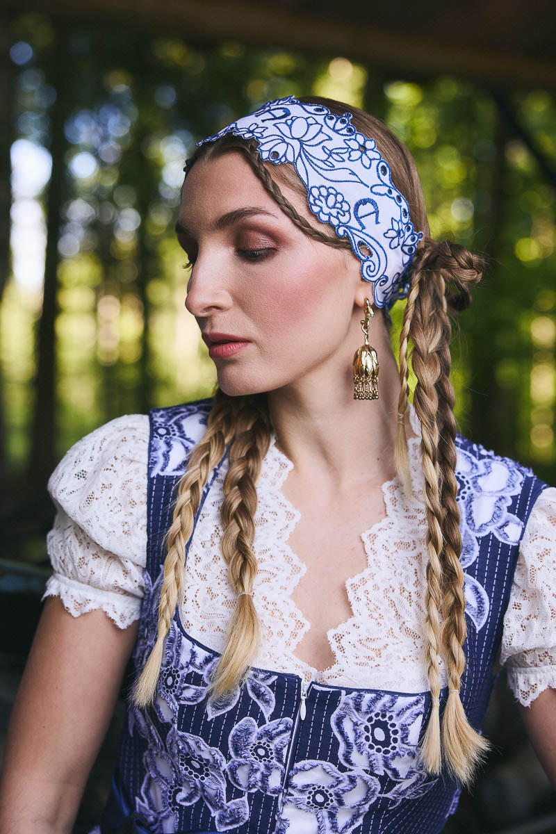 Romantisches Trachtenportrait Portrait eines Models mit geflochtenen Zöpfen und blauem Dirndl