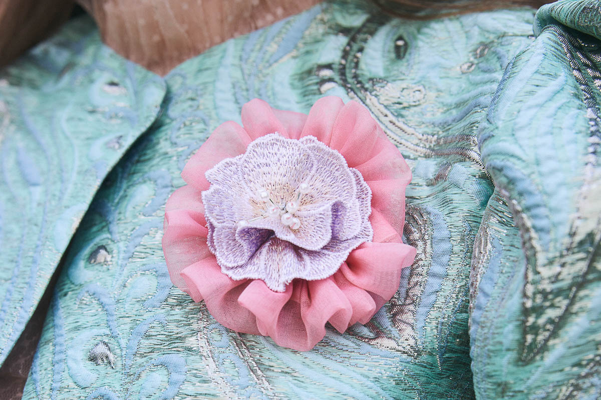 Florale Couture-Details Florale Brosche auf modernem Trachtenlook in Pastellfarben