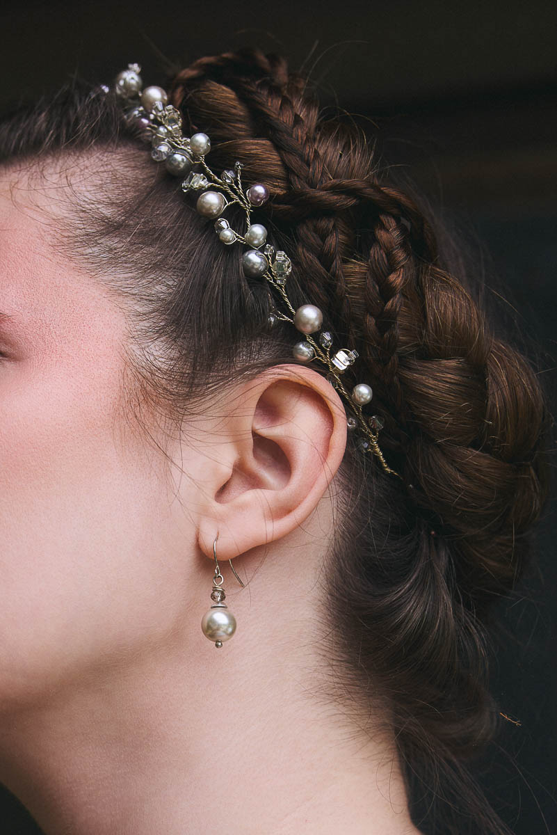 Romantisches Beauty-Detail Geflochtene Frisur mit Perlenschmuck und Ohrring