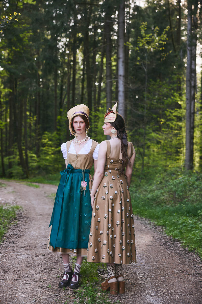Cottagecore Couture im Wald Zwei Models in moderner Trachtenmode auf Waldweg