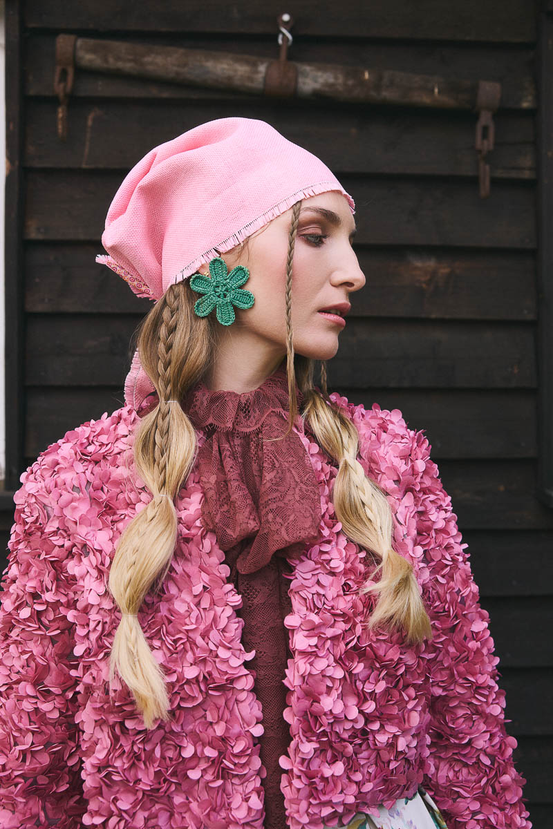 Moderne Cottagecore-Inszenierung Model mit pinkem Kopftuch und floraler Jacke