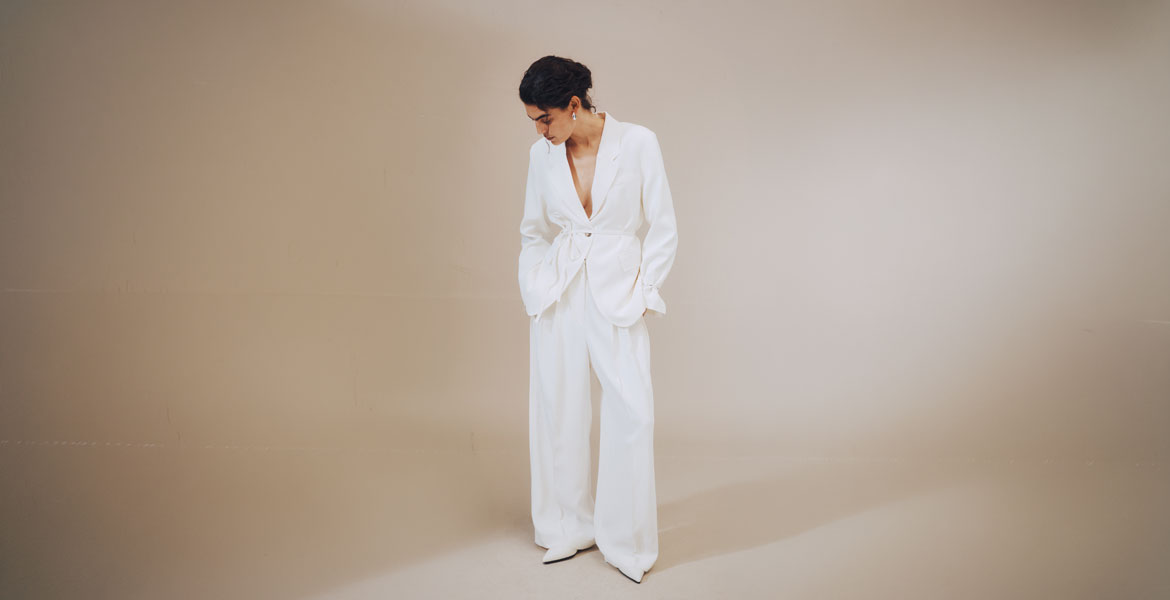 Minimalistischer Womenswear-Look in Cloud Dancer, der Pantone Farbe des Jahres 2026, mit weitem Hosenanzug und monochromem Styling.
