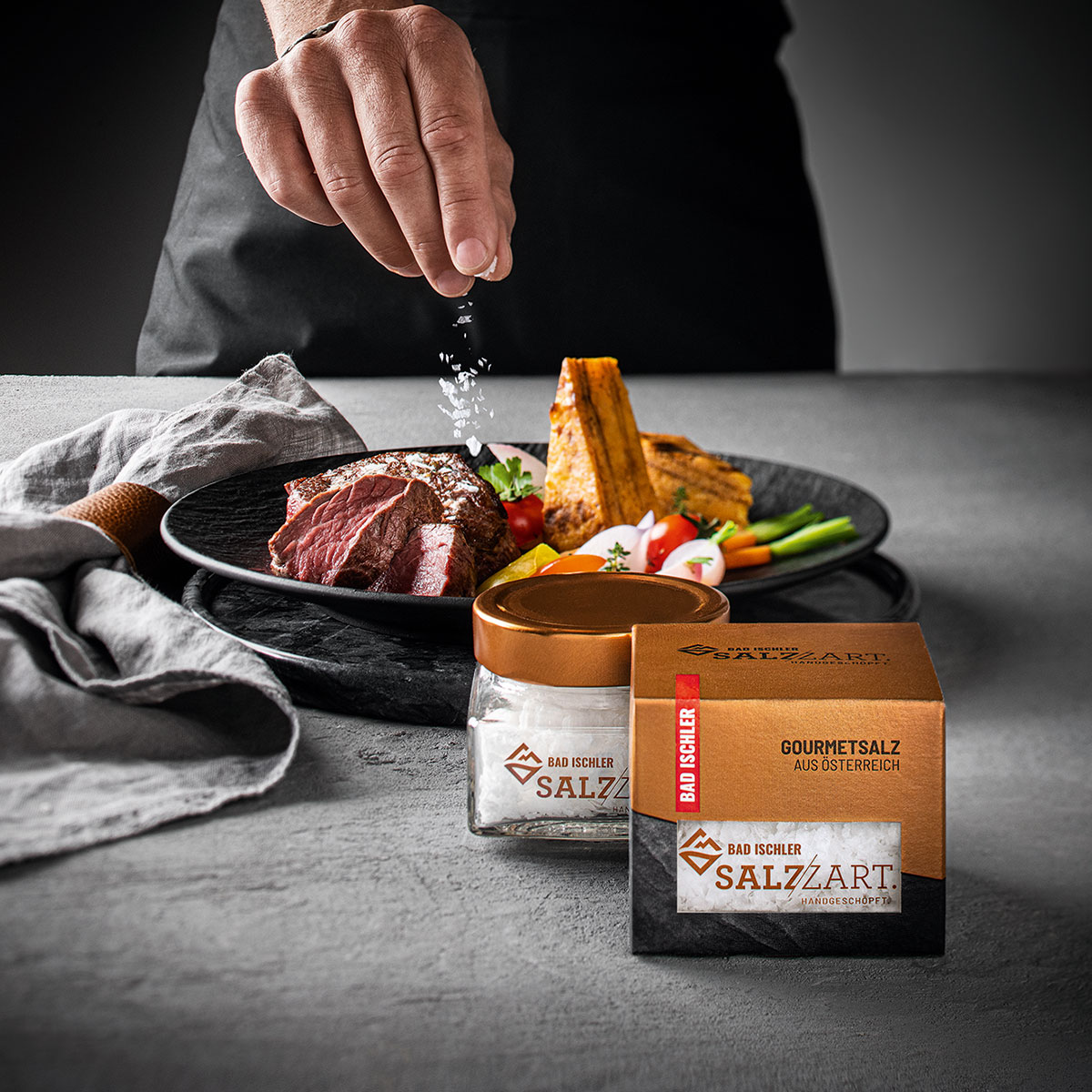 BAD ISCHLER Salzzart wird über einem Steak verteilt