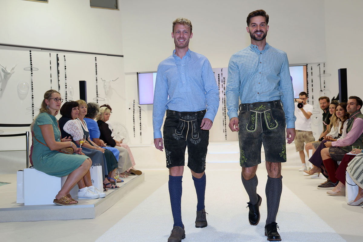 Zwei Models in sommerlicher Herrentracht mit Lederhosen und hellblauen Hemden bei der FESCH.