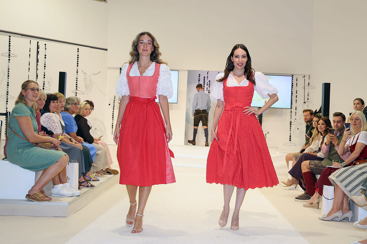 Zwei Models präsentieren kräftig rote und pinkfarbene Trachtenlooks bei der FESCH Fashion Show.