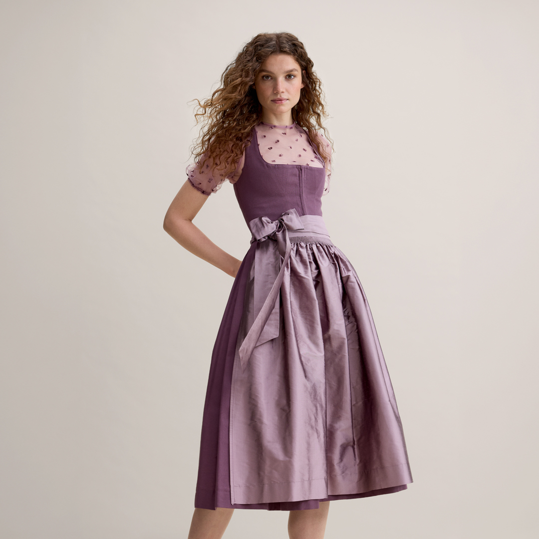 Dirndl in Mauve – Trachtenmode 2026 Mauvefarbenes Dirndl mit transparenter Dirndlbluse von Ludwig Beck